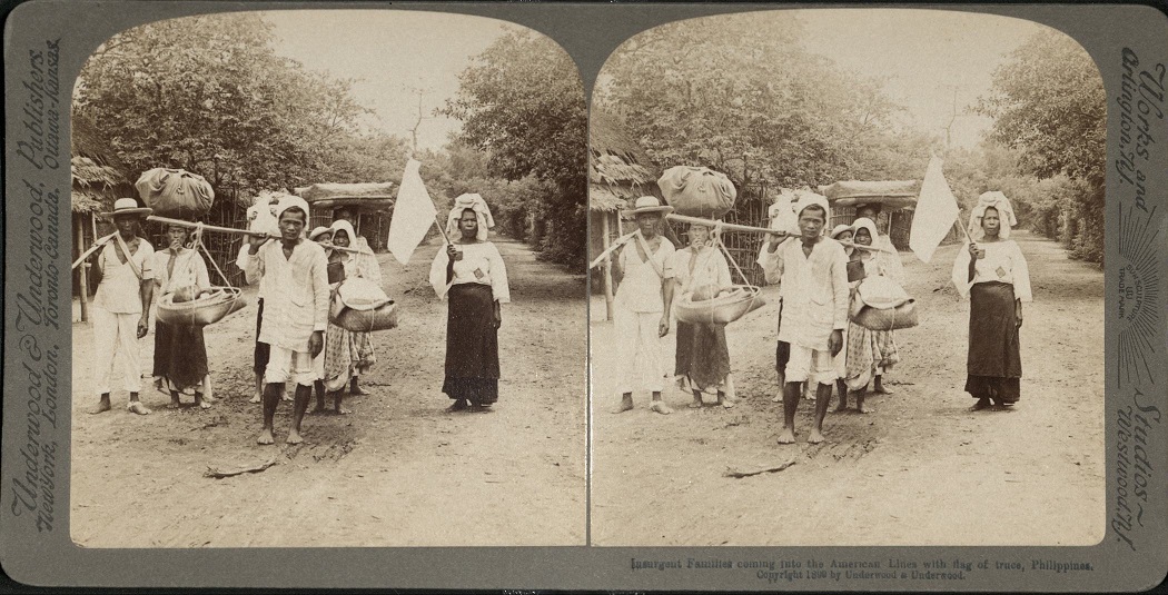 Insurgent Families coming into the American Lines with flag of truce, Philippines.